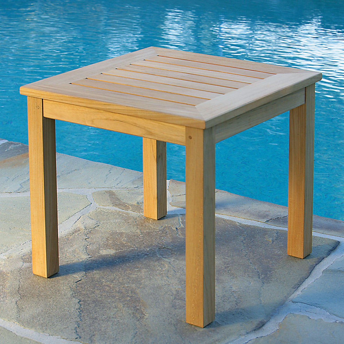 Kingsley Bate Classic teak 20"H side table on a stone pool deck