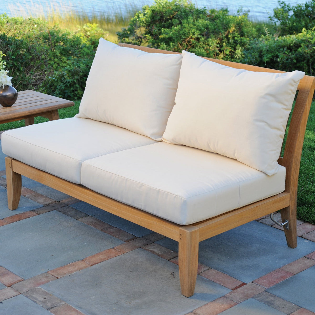 Kingsley Bate Ipanema teak sectional armless settee on a garden patio