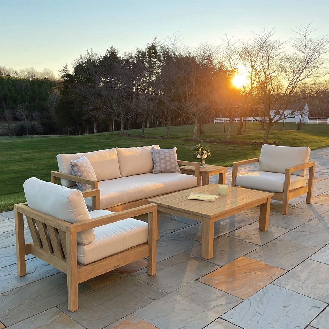 Kingsley Bate Montauk teak sofa and lounge chairs with a Tuscany coffee table on a patio