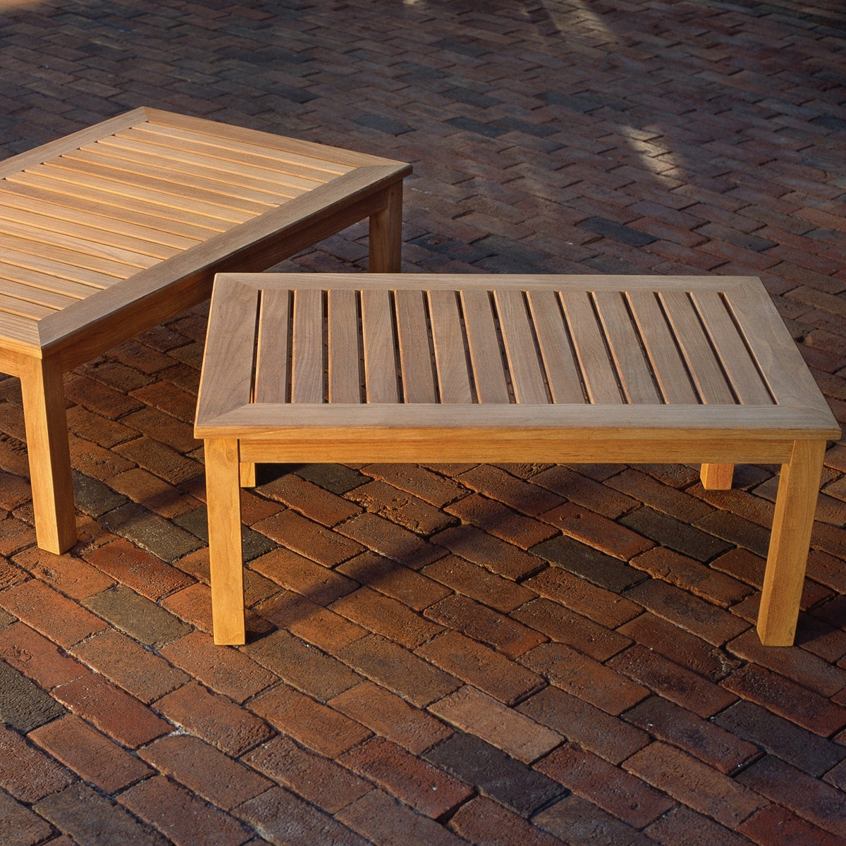 Kingsley Bate Classic teak 38" and 45" coffee tables on a brick patio