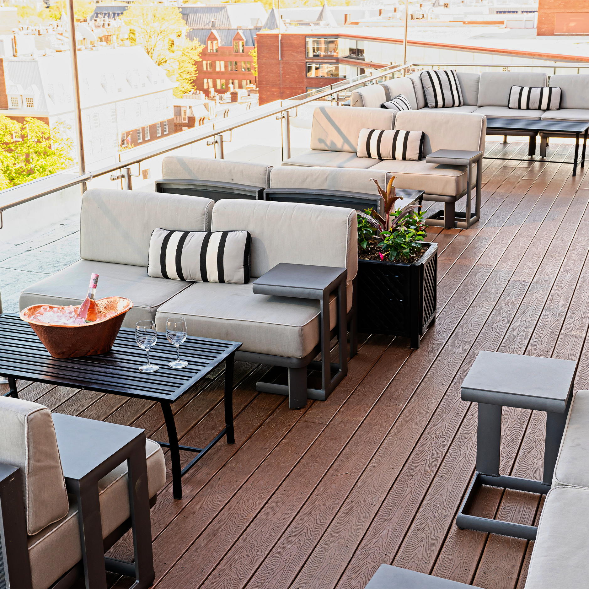 Outdoor patio furniture set on a wooden deck with cityscape in the background