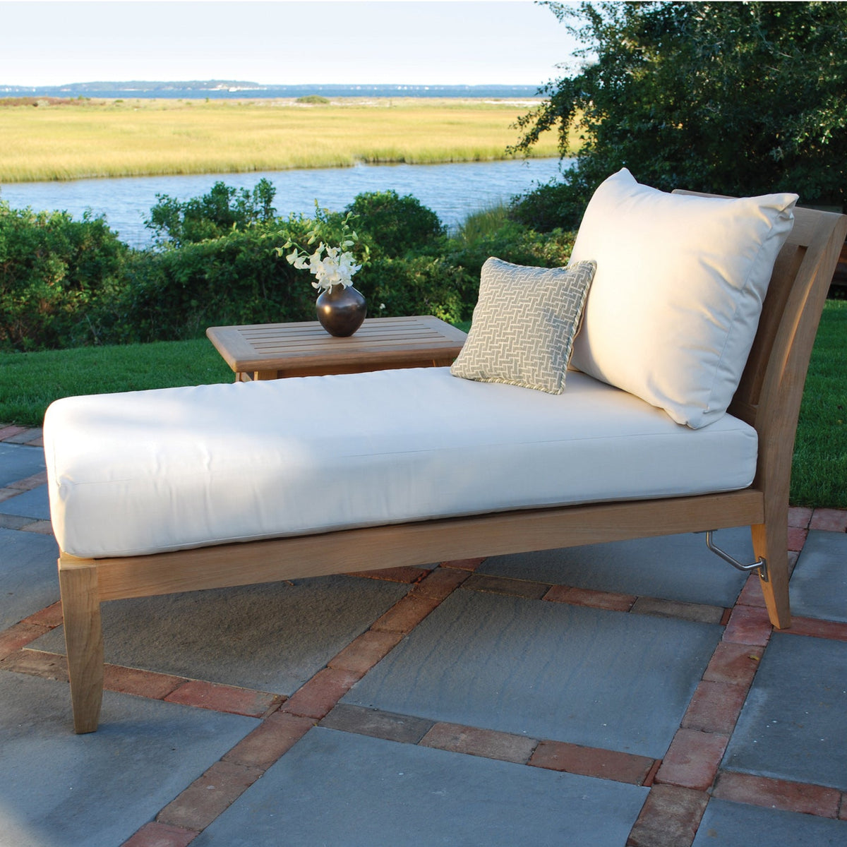 Kingsley Bate Ipanema teak sectional chaise lounge on a patio overlooking the water