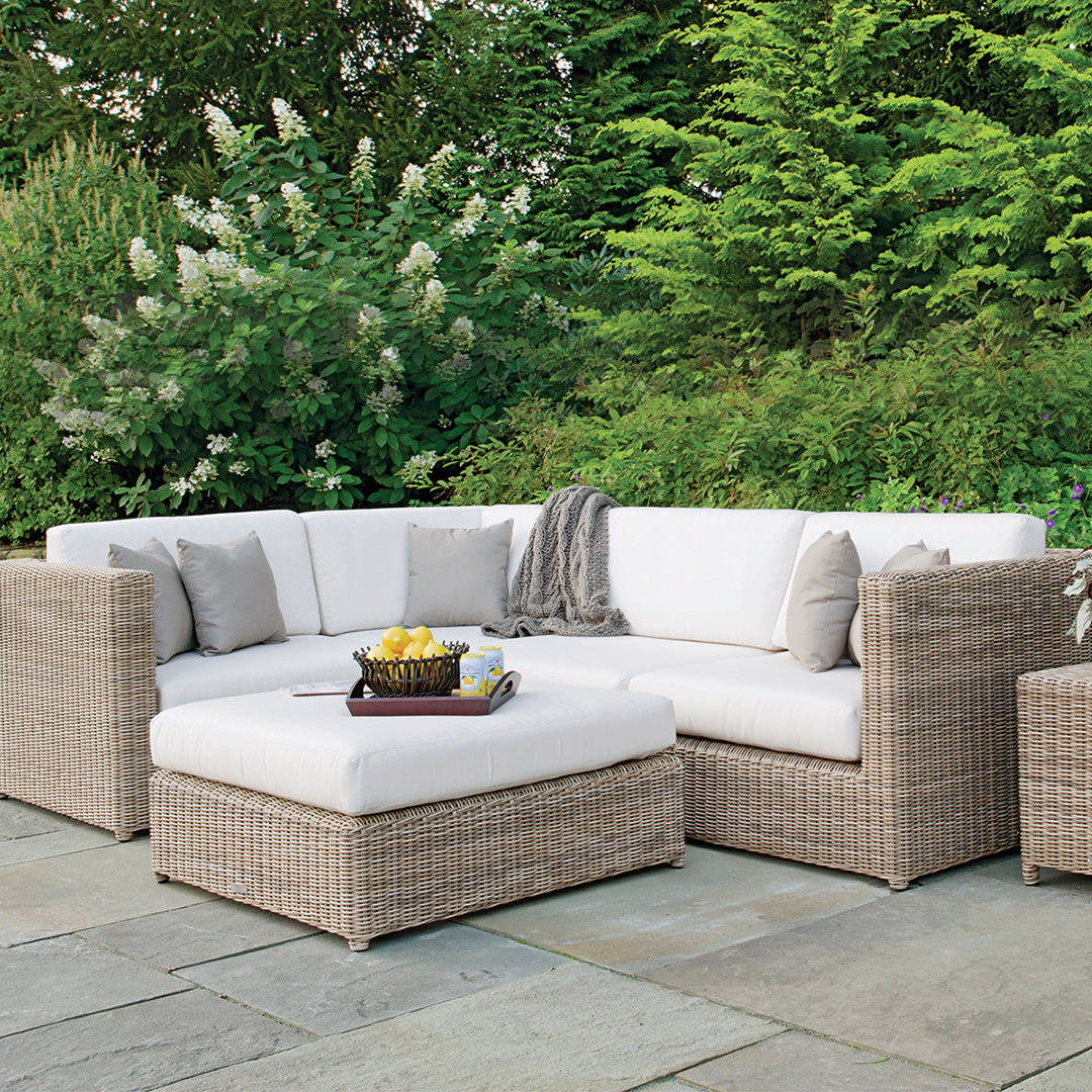 Kingsley Bate Sag Harbor wicker sectional with armless chairs in a garden